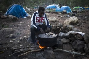  In this Sunday, Nov. 9, 2014 file photo, a Guinean immigrant cooks dinner at a clandestine immigrant camp located at the Mount Gourougou, in the Moroccan province of Nador. Moroccan security forces have arrested hundreds of people in a sweep through a mountainous area where migrants had been living near the Spanish coastal enclave of Melilla, activists said Wednesday, Feb. 11, 2015. The Moroccan Association for Human Rights said that 1,200 migrants had been detained and most bussed to remote parts of the country in the south in an apparent effort to prevent them from trying cross into the Spanish enclave. (Santi Palacios, File/Associated Press)