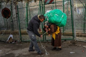 A man ties a huge package onto a woman's back(David Ramos/Getty Images)