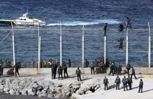 African migrants climb the fence that separates Morocco from the Spanish enclave of Ceuta in North Africa in February. Those who make it into Ceuta have reached Spanish — and European Union — soil. Their fate often depends on the country they came from. Some are deported, while others can apply for political asylum or for the status of economic migrant. Reduan/EPA/Landov